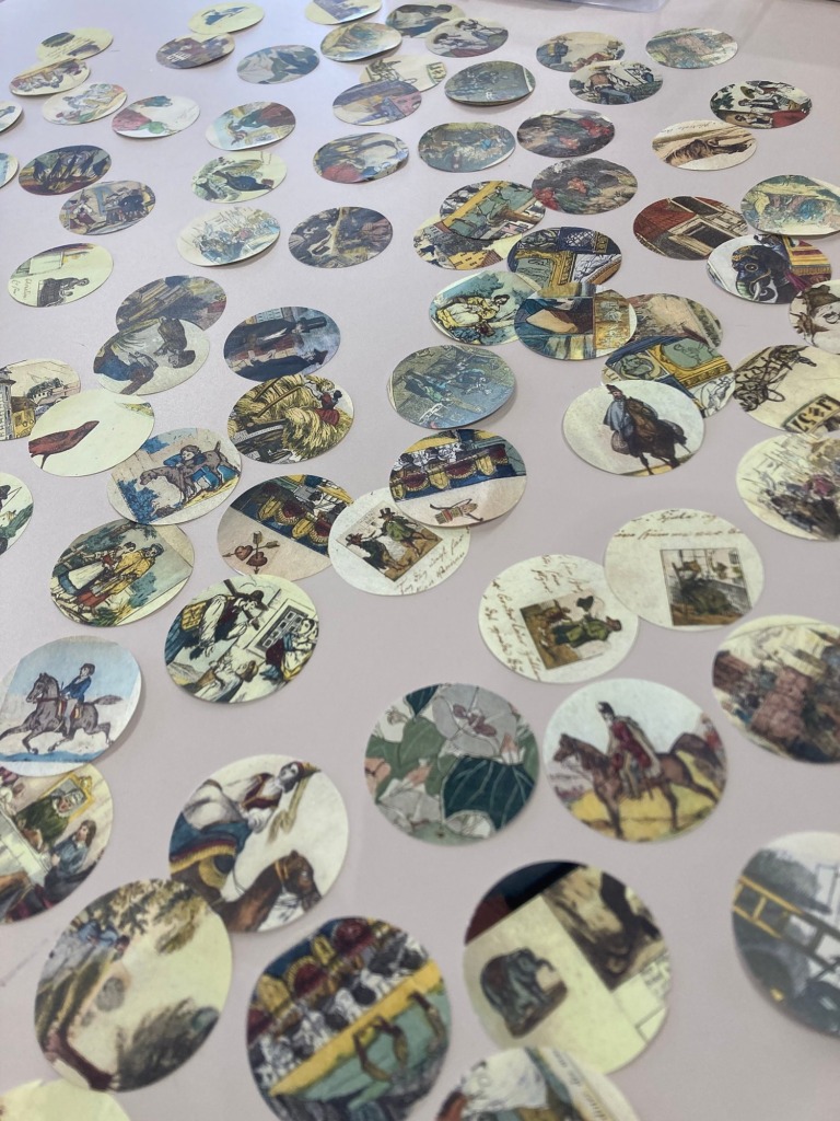 Circles cut from old book illustrations, ready to become button badges